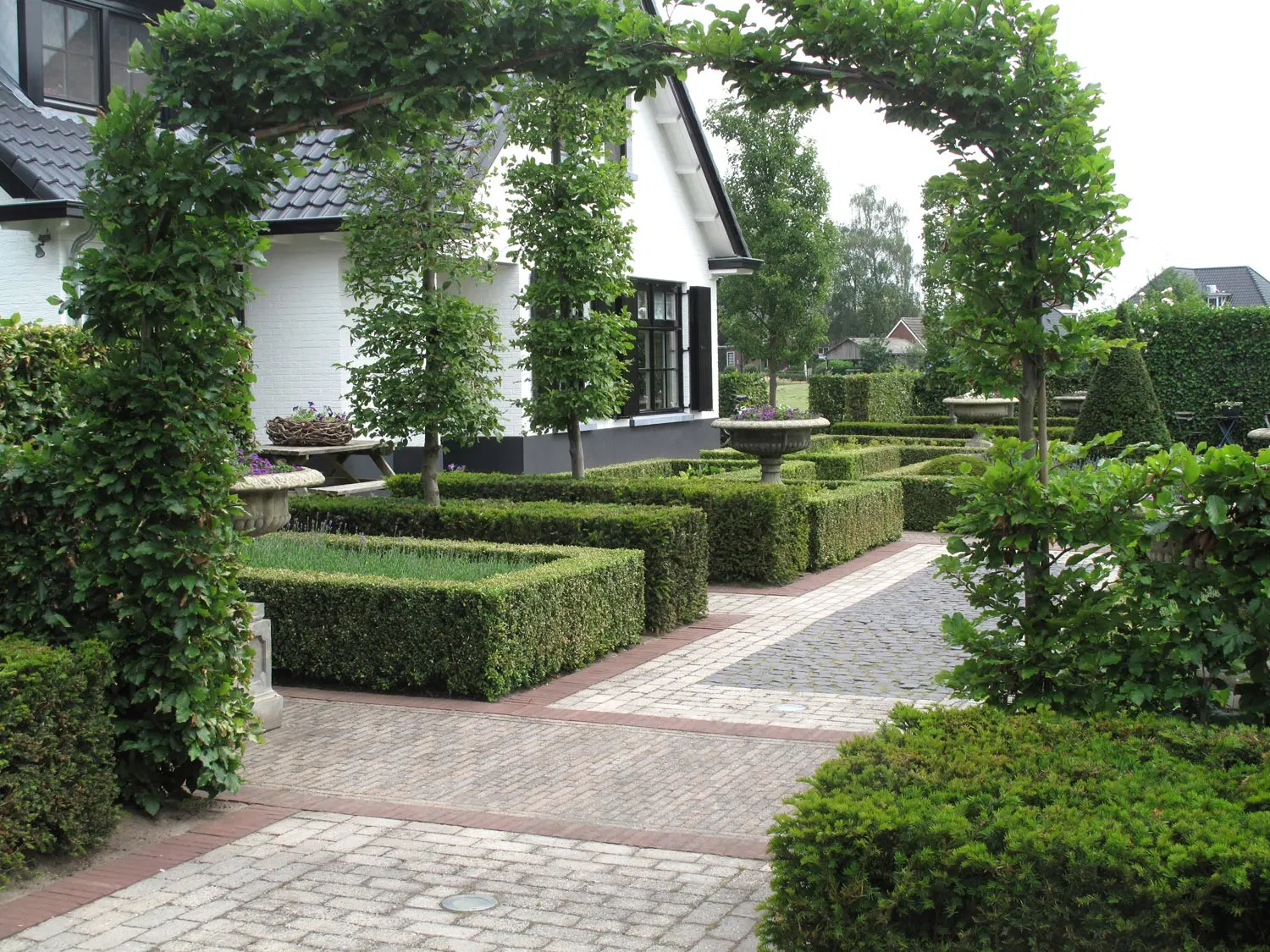 Diabolo: Geometrische haagblokken | Het Buitenland Tuin en Landschap (tuinontwerp Nijmegen, tuinarchitect Nijmegen) Geometrisch patroon van haagblokken gezien door haagboog